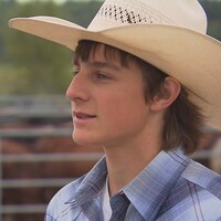 Un jeune homme qui porte un chapeau de cowboy.