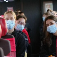 Des joueuses masquées sont assises dans l'autobus 