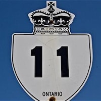 Une affiche de la route 11 sur fond de ciel bleu.