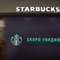 Un homme marche devant une enseigne Starbucks à Saint-Pétersbourg.