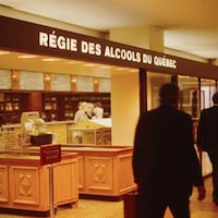 Des gens circulent devant une succursale de la Régie des alcools en 1973.