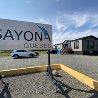 Photo extérieure des bureaux de Sayona Québec, à La Motte, avec l'affiche à l'avant-plan.