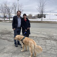 Sébastien Lemire et sa conjointe Émilie Auclair sont devant un parc avec leur chien.