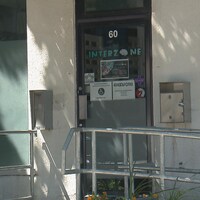 L'entrée d'un local. Sur la porte vitrée, il est marqué Interzone et le numéro 60.