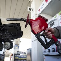 Une femme fait le plein à une station-service.