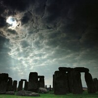 On voit le monument de pierres dressées de Stonehenge, sous un ciel nuageux. 