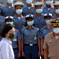 La présidente taïwanaise marche devant des cadets de la marine chinoise en uniforme.