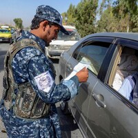 Un soldat taliban vérifie les papiers d'un automobiliste.