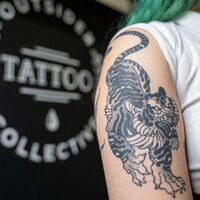 Un tatouage de tigre sur le bras d'une jeune femme.