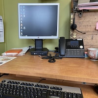 Un ordinateur sur un bureau avec un téléphone à côté. 