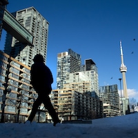 Un passant dans un quartier de tours de logements à Toronto.