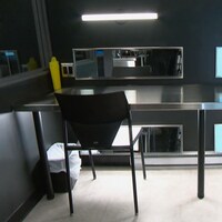 Une salle d'injection où sont disposés des seringues et des contenants à déchets sur une table stérile en aluminium.