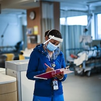 Health-care worker Nalini Persaud looks at her clipboard in the dialysis unit as she audits different health units for hand hygiene and sanitization at the Humber River Hospital during the COVID-19 pandemic in Toronto on Wednesday, December 9, 2020. THE CANADIAN PRESS/Nathan Denette
