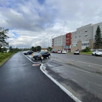Une rue avec un trottoir asphalté sur la gauche.