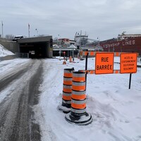 Des panneaux de signalisation temporaire devant le tunnel indiquent que la rue est fermée.
