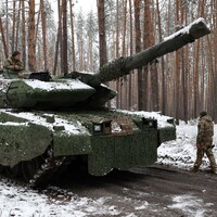 Un char de combat dans un boisé enneigé.
