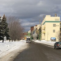 Un camion et des voitures garés devant l'usine Fortress de Thurso en hiver.