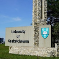Gros plan sur le monument en pierres planté à l'entrée de l'Université de la Saskatchewan sur lequel est inscrit le nom de l'établissement.