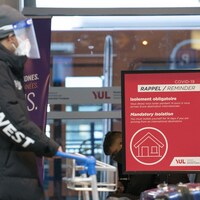 Une pancarte à l'aéroport Montréal-Trudeau rappelle aux voyageurs de faire leur quarantaine. 