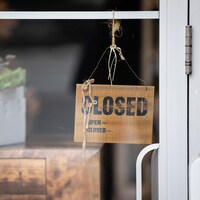 Un panneau qui indique « fermé » devant la vitrine d'un commerce.
