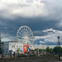 Un quartier touristique du Vieux-Port de Montréal, près du fleuve. La grande roue sous un ciel nuageux.