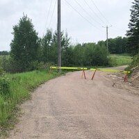 Deux barrières bloquent une route rurale.