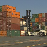 Plusieurs conteneurs de marchandises empilés dans le port de Montréal.