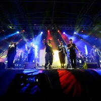 Les membres du groupe Wu-Tang Clan en train de donner une performance sur une scène de festival.