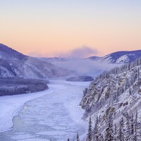 Un fleuve partiellement gelé entouré de montagnes, au Yukon
