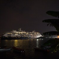 Le paquebot Zaandam illuminé flotte dans le canal de Panama en pleine nuit.