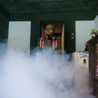 Un militaire cubain porte un masque lors d'une opération de fumigation.