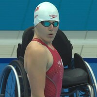 Une nageuse paralympique et son fauteuil roulant.