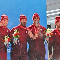 Justin Kripps, Ryan Sommer, Cam Stones et Benjamin Coakwell sourient, médaille de bronze au cou.