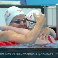 Les nageuses canadiennes Dannielle Dorris et Camille Bérubé s'enlacent dans la piscine par-dessus la bouée.