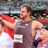 Le para-athlète canadien Greg Stewart prenant une photo avec deux autres participants du lancer du poids après son record paralympique.