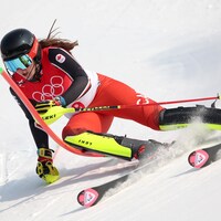 Une skieuse passe un piquet pendant une épreuve de slalom.