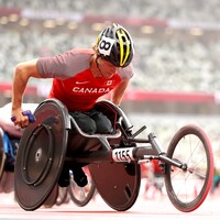 L'athlète s'est penché dans son fauteuil roulant se tenant prêt pour s'élancer dès le coup du départ de la course. 