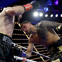 Deux boxeurs échangent des coups dans un ring.