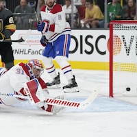 Le gardien du Canadien est en plein vol, plonge pour essayer d'arrêter un tir à sa droite, mais la rondelle est derrière lui, dans le filet.