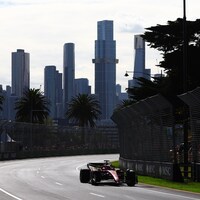 Une voiture de course en piste avec la ville de Melbourne en arrière-plan.
