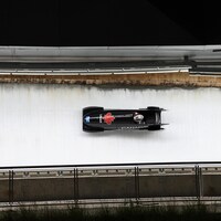 Prise de vue au-dessus d'un bobsleigh qui file en ligne droite sur la piste.