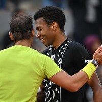 Nadal félicite son adversaire qui offre un sourire malgré la défaite. 