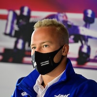 Le pilote de formule 1 est masqué et donne une conférence de presse.