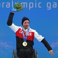 Le paraskieur Josh Dueck lève ses bras après l'obtention de sa médaille d'or au super combiné de Sotchi, en 2014.