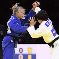 Deux judokas s'affrontent en compétition.