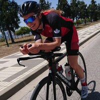 Jeune femme souriante, sur un vélo.