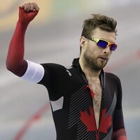 Vêtu de sa combinaison de patineur, il lève le point droit.