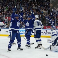 Deux joueurs de hockey lèvent les bras au ciel.