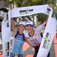 Un couple d'athlètes prend une pose pour la photo au fil d'arrivée d'un Ironman à Augusta, en Georgie, en 2016.