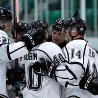 Des joueurs de hockey s'enlacent après avoir marqué un but.